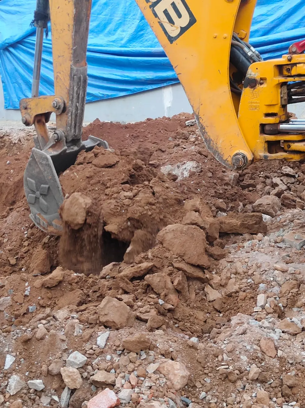 JCB excavator removing earth and rubble on Bangalore site